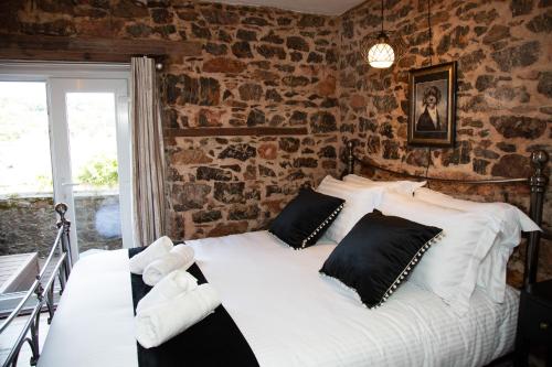 托基Quirky Boutique 1840s Stable的卧室配有一张带黑色枕头的大型白色床。