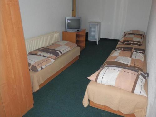 俄斯特拉发Ubytovna u hospůdky的一间设有两张床和电视的房间