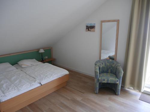 奥斯特巴德·哥伦Apartmentanlage-Villa-Granitz in Göhren的一间卧室配有一张床、一把椅子和镜子