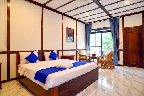 暹粒Daisy Angkor Bungalow的一间卧室配有一张带蓝白色床单的大床