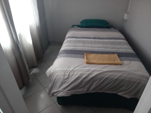 比勒陀利亚Las Palmas Day & Night Guest House的房间里的一张带毛巾的床