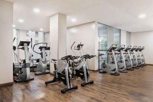 林茨林茨万怡酒店的一间健身房,里面设有一排跑步机和椭圆机