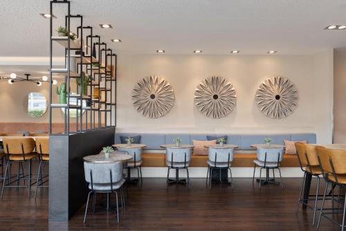 林茨林茨万怡酒店的餐厅设有桌椅和镜子