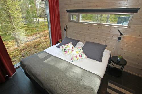 库萨莫Villa Kanger Ruka 2的卧室配有带枕头的床铺和窗户。