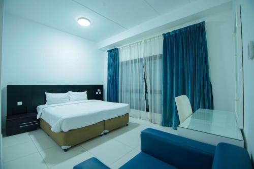 迪拜Home Away Holiday Homes的卧室配有床、椅子和窗户。