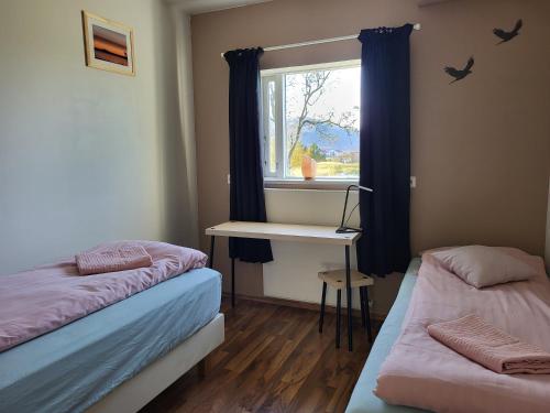 HvanneyriHvanneyri apartment的客房设有两张床、一张桌子和一个窗户。