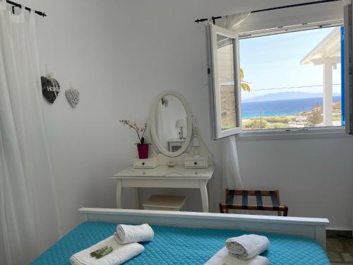 卡拉法蒂斯Venus Myconian Residences的浴室设有镜子,床上配有2条毛巾