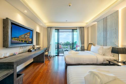 华欣Treepana Boutique Hotel, Huahin的酒店客房设有两张床和电视。