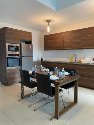 吉隆坡Reizz Residence By Leo Suites的厨房配有木桌、椅子和电器