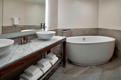 圣安东尼奥San Antonio Marriott Northwest Medical Center的浴室设有2个水槽、浴缸和镜子
