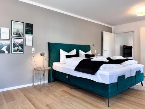 斯图加特Appartio: Geräumige, moderne Ferienwohnung für Gruppen/Familien的一间卧室配有一张大床和绿色床头板