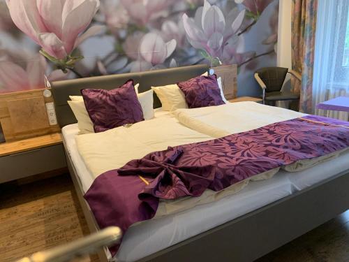 布劳恩拉格Hotel Paidion的一张带紫色和白色床单及枕头的床