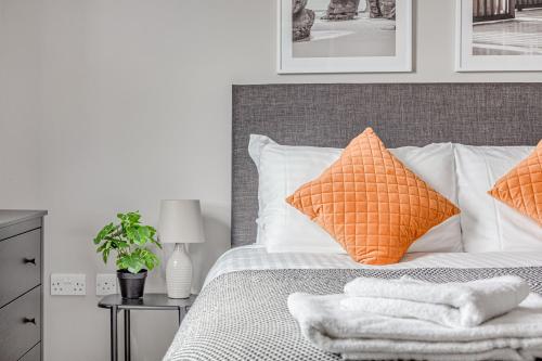 彻特西Contemporary 2 BR apt, town centre by tent serviced apartments的一间卧室配有带橙色和白色枕头的床
