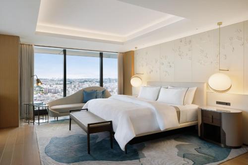 横滨横滨威斯汀酒店(The Westin Yokohama)的卧室配有一张白色的大床和一张沙发。