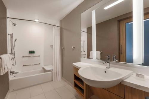 塔拉哈西SpringHill Suites by Marriott Tallahassee North的白色的浴室设有水槽、浴缸和淋浴。
