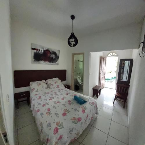 瓜拉派瑞Pousada Casa Verde的一间卧室配有一张带花卉床罩的床