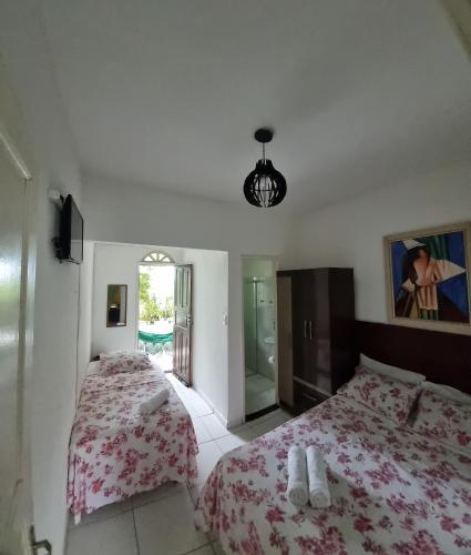 瓜拉派瑞Pousada Casa Verde的一间卧室配有两张床和镜子