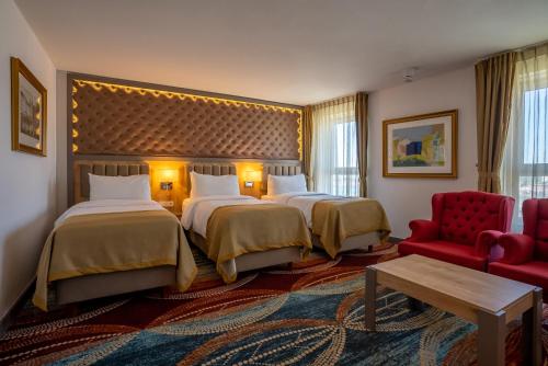 鹿特丹ART Hotel Rotterdam-Fully Renovated的酒店客房,设有两张床和一张红色椅子