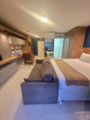 巴西利亚Vision Executive Premium Esplanada的一间大卧室,配有一张大床和一张沙发