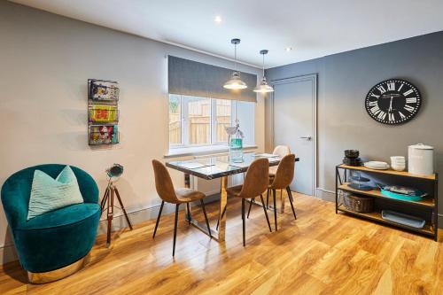 阿尼克Host & Stay - Narrowgate Apartments的一间带桌椅和时钟的用餐室