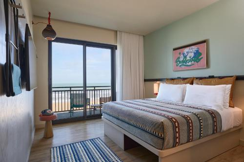 弗吉尼亚海滩Moxy Virginia Beach Oceanfront的一间卧室设有一张床和一个大窗户