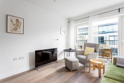 伦敦Modern Chelsea Apartment的客厅配有平面电视和沙发。