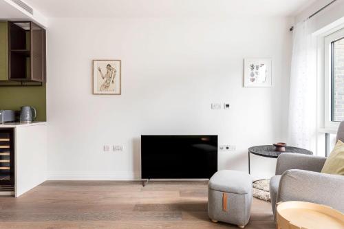 伦敦Modern Chelsea Apartment的白色的客厅配有电视和桌子