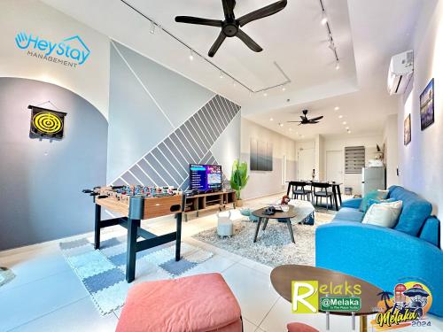 马六甲OngKimWee Residence By Heystay Management的客厅配有乒乓球桌和蓝色沙发