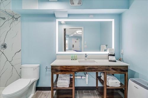 阿兰瑟斯港Seaside Boutique Hotel, Waves At Your Doorstep的一间带水槽、卫生间和镜子的浴室