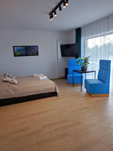 马佐夫舍地区格罗济斯克Aquarius Stawy Walczewskiego 7的一间卧室配有一张床和两张蓝色椅子