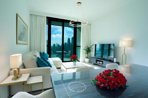 迪拜Stunning Apartment with Direct access to Dubai Mall的一间带大白色沙发的客厅和一间带鲜花的客厅