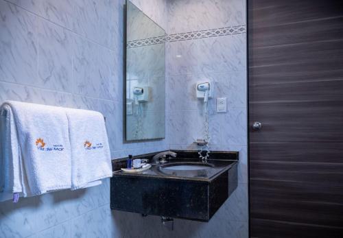 墨西哥城Hotel Villa del Mar的浴室配有盥洗盆、镜子和毛巾