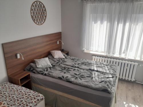 兹维日涅茨Miodowa的一间卧室配有一张带木制床头板的床
