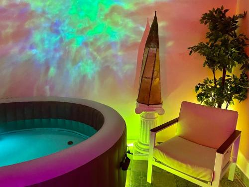 GagnyEspace détente jacuzzi sauna的带浴缸、椅子和彩虹的房间