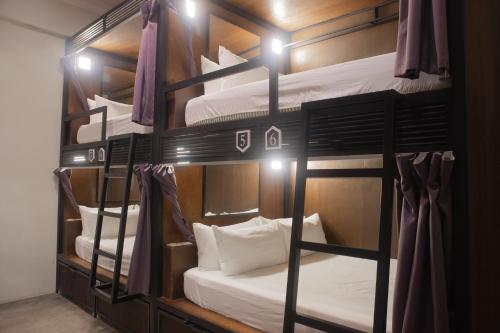 马六甲Sleep Here Hostel, Melaka的一间设有四张双层床的客房,配有灯