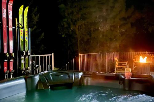 大熊湖Winter Getaway Spa Fire-table Close to slopes的热水浴池配有滑雪板和桌椅