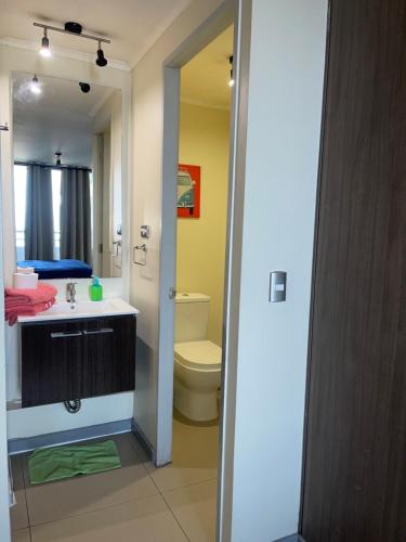 圣地亚哥Yolier Suites的一间带水槽、卫生间和镜子的浴室