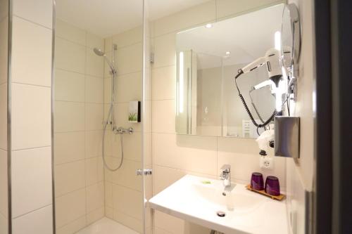 格尔斯托芬罗马德特酒店的带淋浴、盥洗盆和镜子的浴室