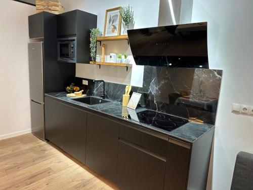 瓦伦西亚Bear Homes - Olimpia Suite的厨房配有黑色橱柜和台面