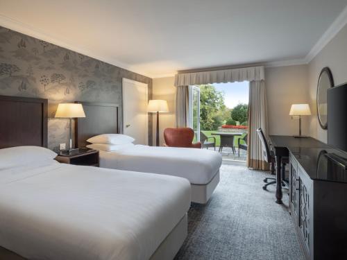 切普斯托Delta Hotels by Marriott St Pierre Country Club的酒店客房配有两张床和一张书桌