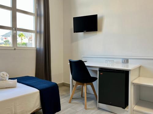 Buzanada卡桑德拉酒店的客房设有书桌、椅子和床。