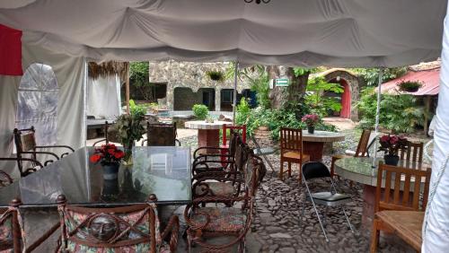 San AntonioLA CASA DE LOS MANGOS AJIJIC的帐篷下设有带桌椅的天井。