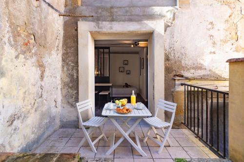 卡斯泰尔诺达里LE COSMO Du Grand Bassin Avec Terrasse的庭院配有白色的桌椅和桌子