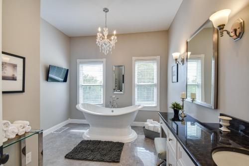 Rural Biggsville Vacation Rental with Porch的一间带大型白色浴缸和吊灯的浴室
