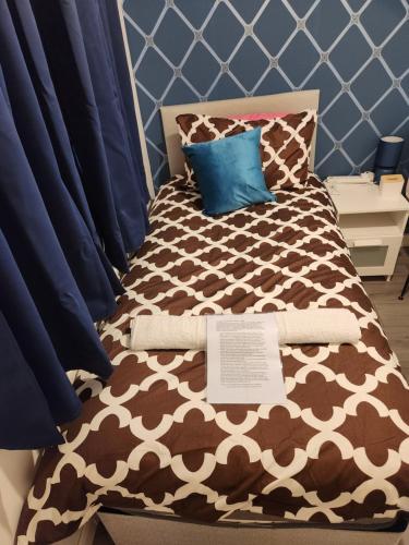 克劳利Swift Stop Night Stay - Gatwick的一张带棕色和白色棉被和枕头的床