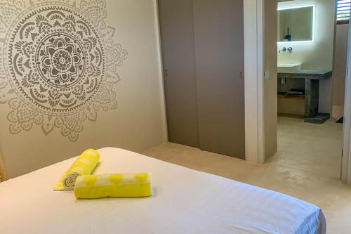 克拉伦代克Isla penthouse & garden apartments Bonaire的一间卧室配有一张带黄色枕头和水槽的床