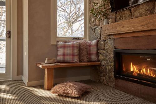 佩里舍峡谷Lodge Chalet 28 - The Stables Perisher的客厅设有壁炉和长凳