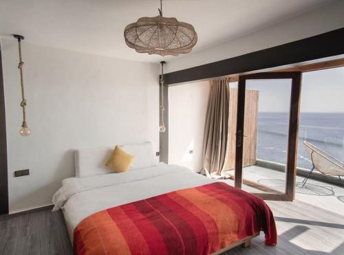 塔哈佐特Oceana Surf Camp的一间卧室设有一张床,享有海景