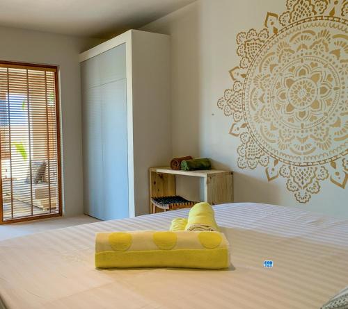 克拉伦代克Isla penthouse & garden apartments Bonaire的上面有一个黄色物体的床