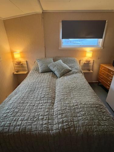 Nord-LenangenHos Laura & Valdemar的一间卧室配有带两个枕头的床和窗户